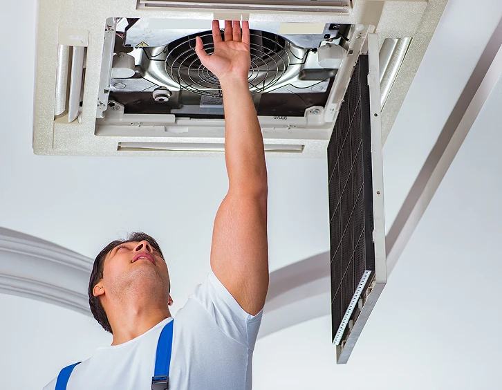 AC technician working on ceiling air conditioner in Boca Raton