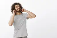 Man plugging ears against air conditioner's loud grinding noises