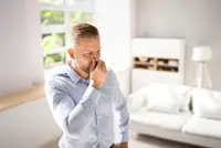 Man plugging his nose against AC smells in Boca Raton